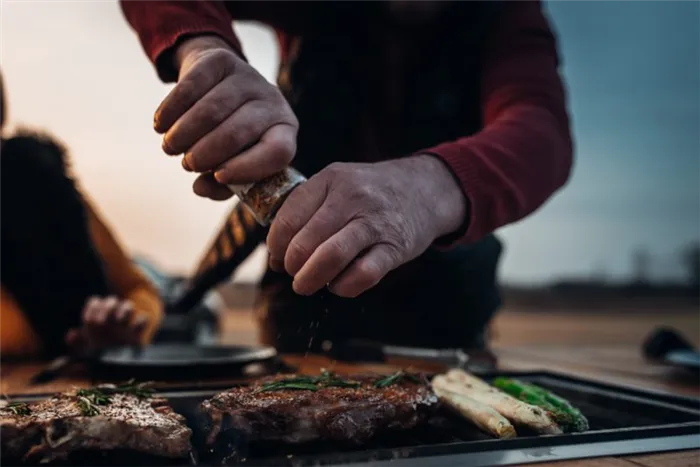 Seasoning meat on a grill