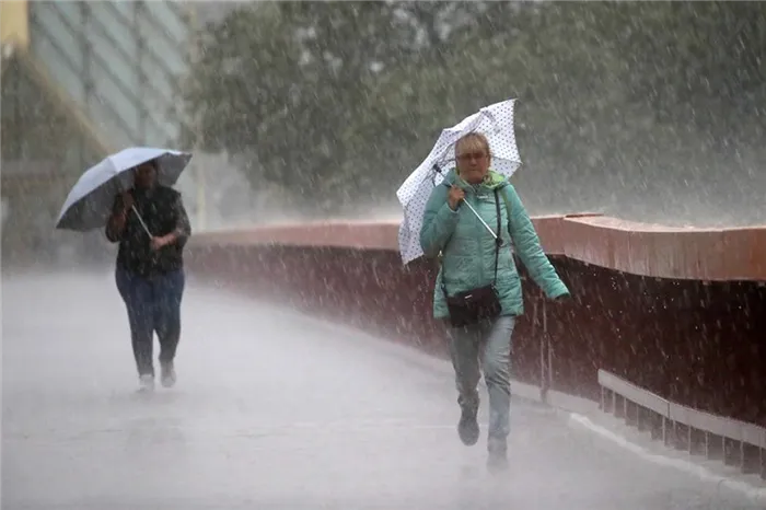 Прохожие во время дождя у Андреевского моста в Москве